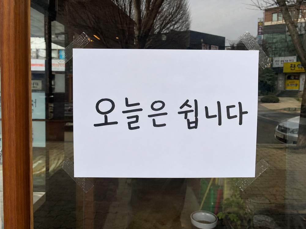 유리문에 테이프로 붙은 하얀 종이. 오늘은 쉽니다라고 굵은 검은 글씨로 정확히 적혀 있다.
